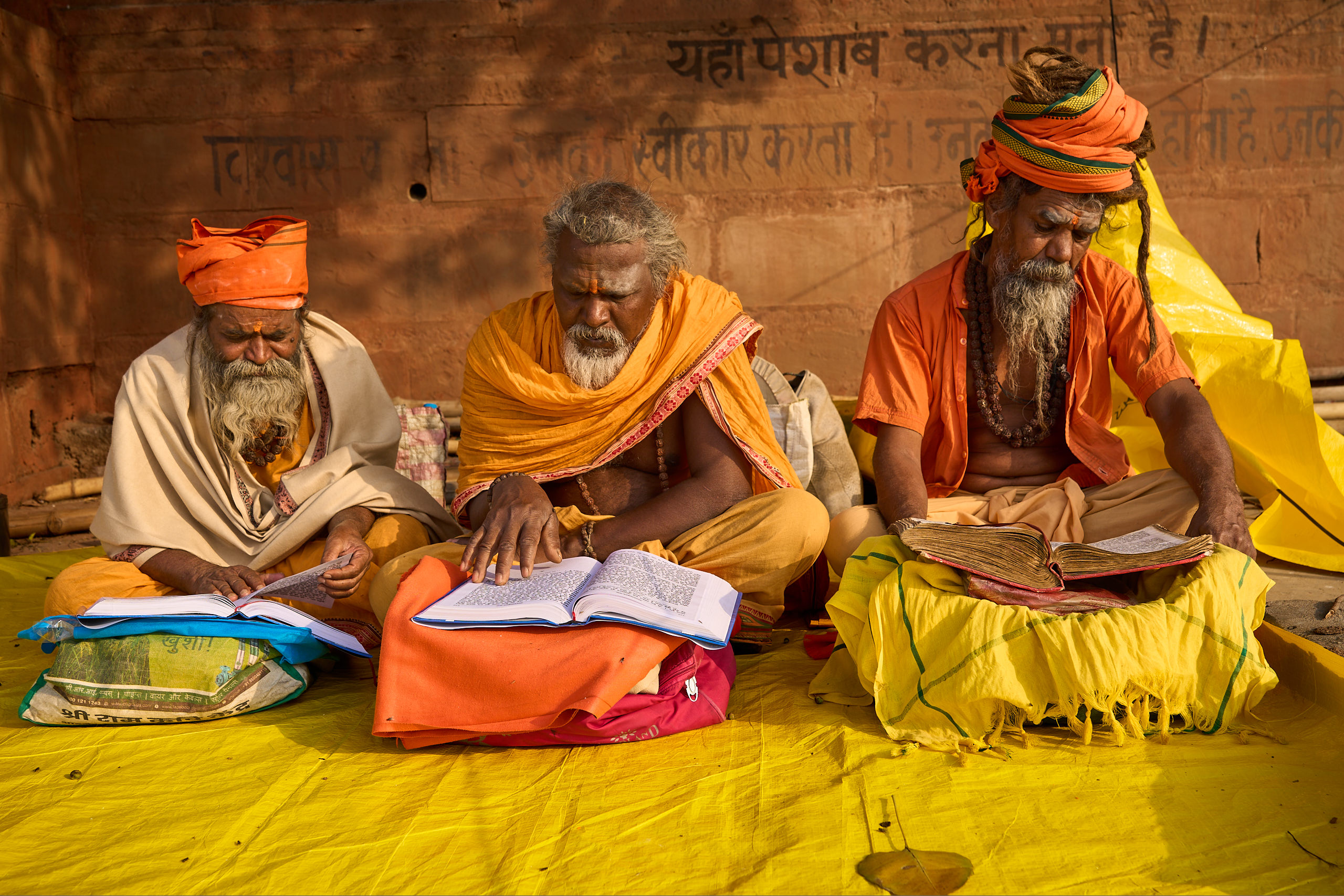 3 Indian holy men studying scripture.